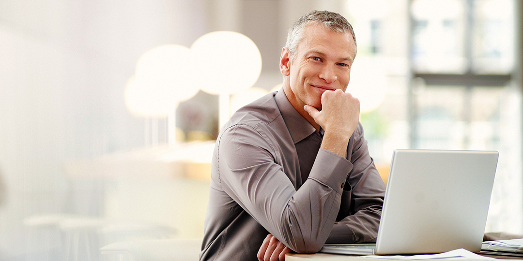 Lächelnder Mann am Laptop