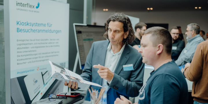 Interflex employees explain kiosk systems for visitor management to interested parties at the Customer Solution Day.