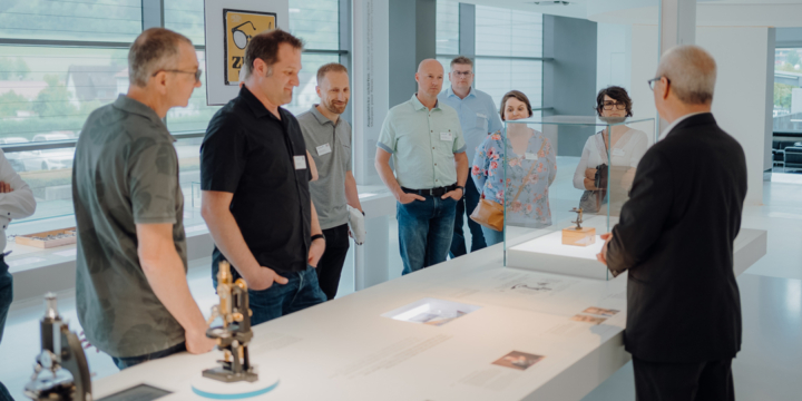 A group of people participates in a company tour at Carl Zeiss