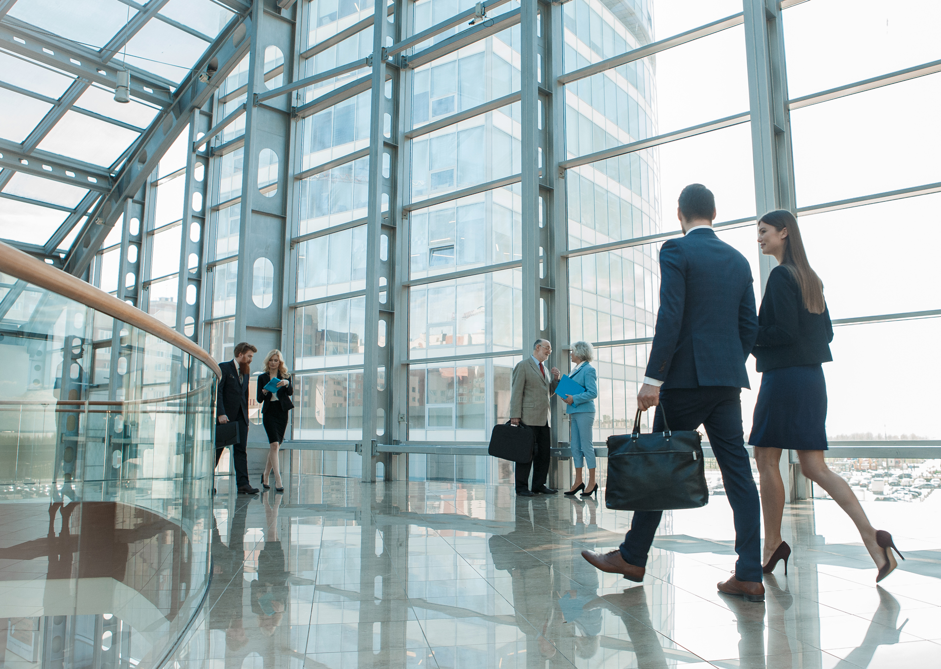 Personen in Gesprächen vertieft laufen durch modernes Firmengebäude