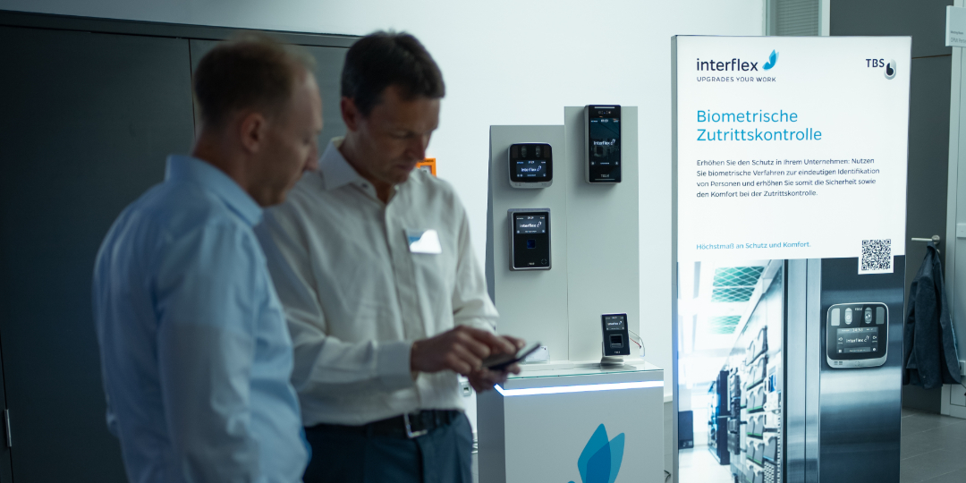 Messe-Stele mit TBS-Biometrieprodukten und zwei Interflex-Mitarbeitern im Gespräch